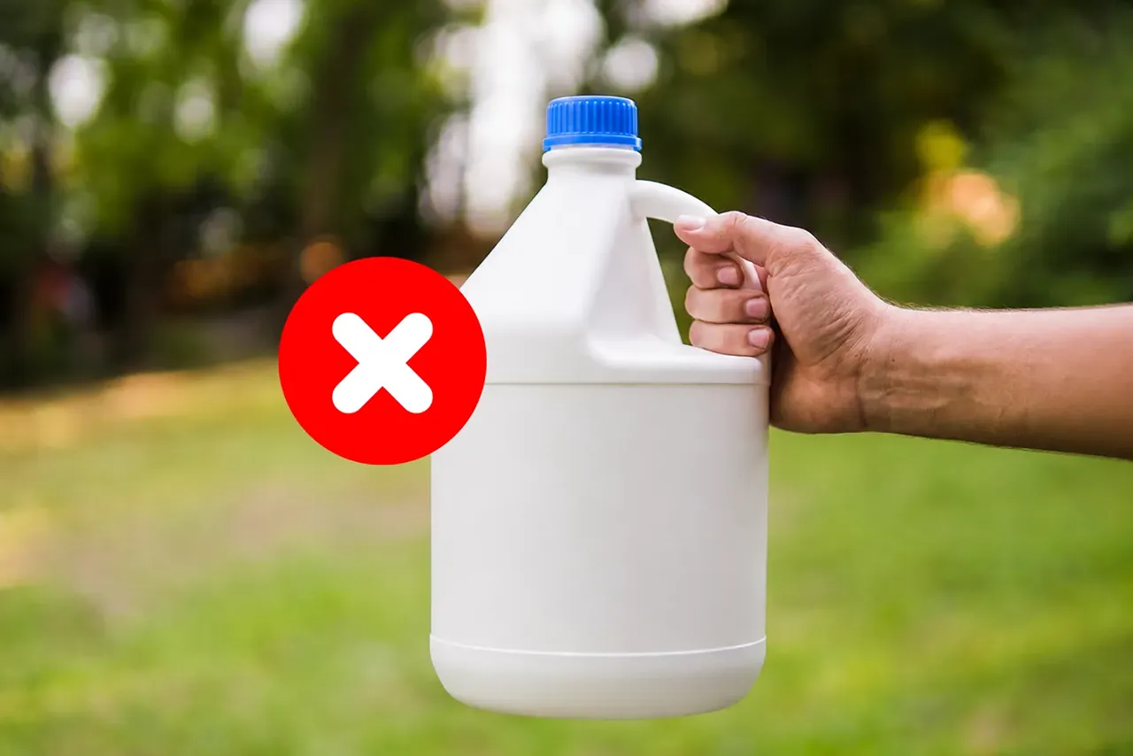 A hand holding bleach gallon